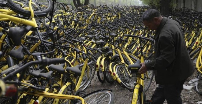 Un mecánico repara una bicicleta de alquiler de la compañía OFO en un depósito que alberga miles de estos vehículos en Pekín (China). EFE/Archivo