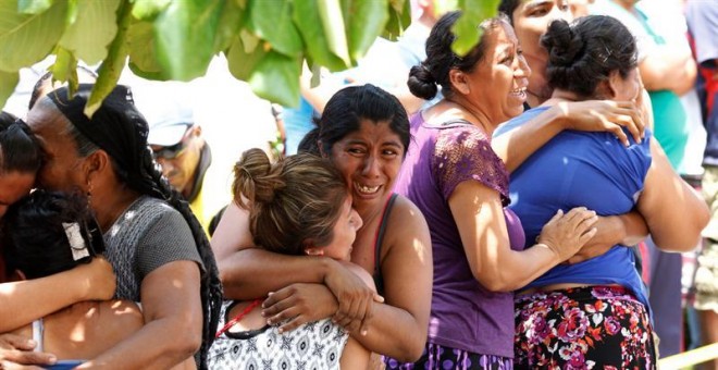Familiares y amigos lloran al ver el rescate del cuerpo de un policía en Juchitán (Oaxaca). / EFE