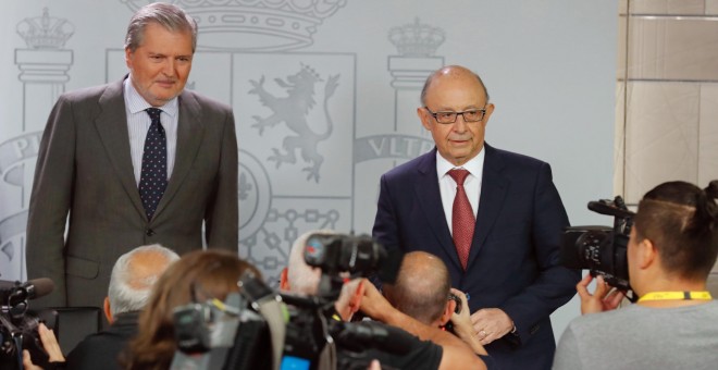 El portavoz del Gobierno y ministro de Educación, Cultura y Deporte, Íñigo Méndez de Vigo (i), y el ministro de Hacienda, Cristóbal Montoro, durante la rueda de prensa posterior a la reunión del Consejo de Ministros celebrada en el Complejo de La Moncloa.