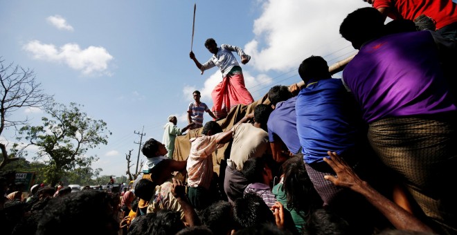 Un hombre usa una vara para controlar a la multitud mientras proporciona suministros de socorro a los refugiados Rohingya en el campamento de Cox, en Bangladesh. REUTERS / Mohammad Ponir Hossain