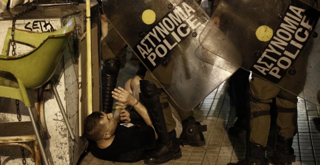 Los policías griegos antidisturbios detienen a uno de los manifestantes de la marcha antifascita en recuerdo del rapero Pavlos Fyssas asesinado por un simpatizante del partido neonazi Amanecer Dorado. EFE/EPA/YANNIS KOLESIDIS