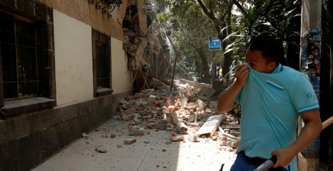 Un hombre se tapa la cara junto a un edificio derruido tras el terremoto en Ciudad de México. - REUTERS