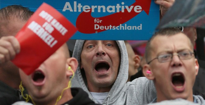 Simpatizantes de Alternativa para Alemania (AfD) gritan durante un acto de campaña de la canciller alemana Angela Merkel el 6 de septiembre del 2017. REUTERS/ Reinhard Krause