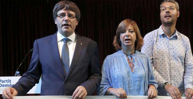 El presidente de la Generalitat, Carles Puigdemont, junto a la consellera de Gobernación, Meritxell Borràs y Eliseo Esterli (d), durante un acto del PDeCAT en el Casino del Centre de L'Hospitalet.| ANDREU DALMAU (EFE)