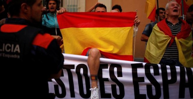 Manifestantes sostienen banderas españolas durante una reunión en apoyo a los guardias civiles españoles fuera de sus cuarteles en Barcelona el pasado ​​21 de septiembre / REUTERS