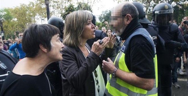 La alcaldesa de L'Hospitalet de Llobregat, Nuria Marin, se enfrenta a un policía fuera de la Escuela Can Vilumara. EFE/Quique García