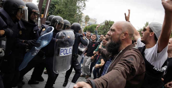 Agentes de la Policía Nacional fretne a las personas concentradas en un colegio electoral en Tarragona, durante la jornada del referéndum del 1-O. REUTERS/David Gonzalez