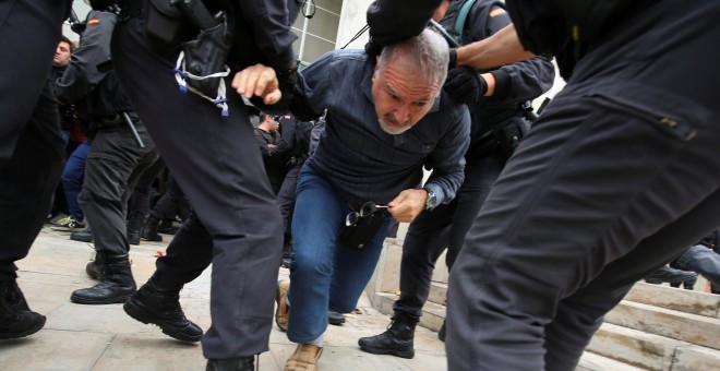 Agentes de la Guardia Civil tiran de un ciudadano frente a un colegio electoral en Sant Julia de Ramis, este domingo. REUTERS/Albert Gea