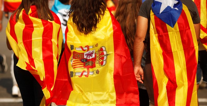 Jóvenes cubiertos con la bandera esañola, la senyera, y la estelada, en la manifestación en Barcelona durante la jornada de paro en protesta por las cargas policiales durante el referéndum del 1-O. REUTERS/Jon Nazca