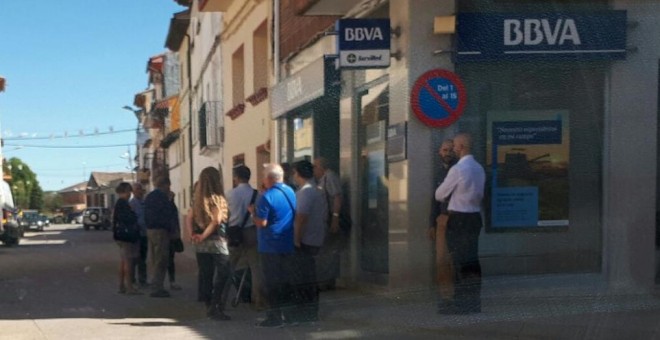 Decenas de clientes catalanes hacen cola ante la sucursal de BBVA de Belver de Cinca. / EDUARDO BAYONA