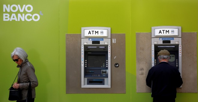 Varios clientes operan en los cajeros automáticos de una oficina de Novo Banco, en Lisboa