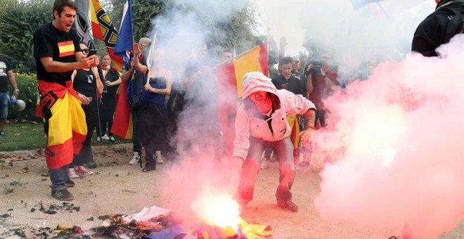Jóvenes de ultraderecha queman estelades durante la manifestación en defensa de la unidad nacional en la plaza de Sant Jordi, en Barcelona./EFE