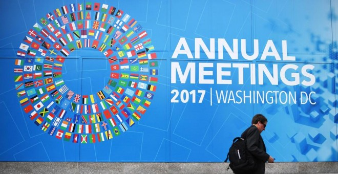 Un caminante pasea junto a la placa que anuncia la reunión anual del FMI. AFP/Jim Watson