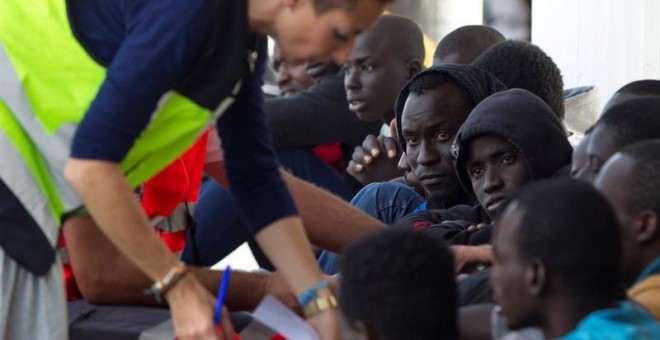 Algunos de los 53 inmigrantes adultos de origen subsahariano que fueron rescatados este viernes, cuando viajaban en una patera a 40 millas al sur del cabo Sacratif en el mar de Alborán, y que han sido trasladados al puerto de Málaga. EFE/Daniel Pérez