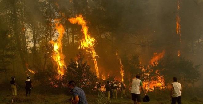 Un grupo de personas tratan de apagar el incendio de Zamanes, Vigo. EFE/Salvador Sas