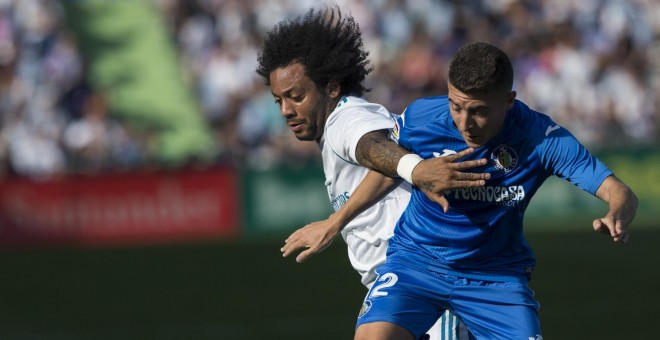 El defensa brasileño del Real Madrid Marcelo Vieira disputa un balón con el centrocampista del Getafe Francisco Portillo  durante el partido de liga disputado en el Coliseum Alfonso Pérez. EFE/Rodrigo Jimenez