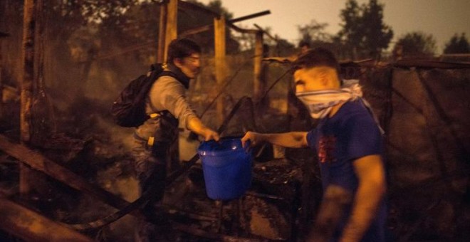 Ciudadanos ayudan a sofocar con cubos de agua uno de los focos declarados en el centro de la ciudad de Vigo. - BRAIS LORENZO