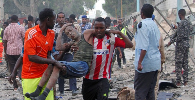 Ciudadanos asisten a un hombre, herido tras la explosión de un coche bomba en Somalia. REUTERS/Feisal Omar