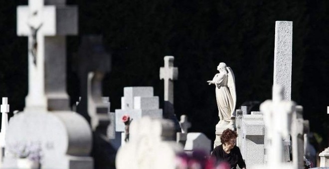 Una mujer visita a sus difuntos en el cementerio de La Almudena de Madrid.- EFE
