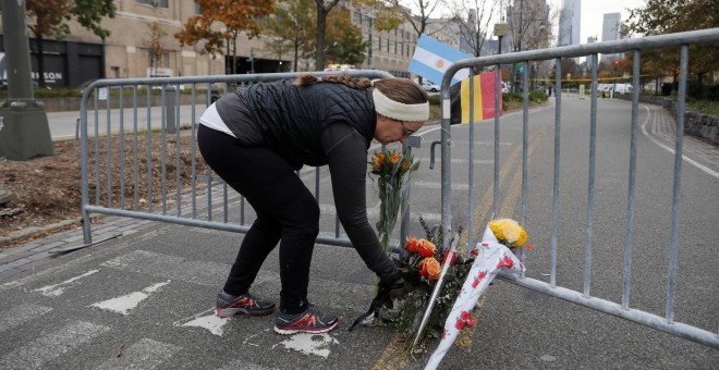 Una mujer deposita flores en la barrera colocada en el caril-bici junto al rio Hudson donde se produjo el ataque terrorista que ha causado la muerte a ocho peatones y ciclistas, arrollados por una furgoneta conducida por un inmigrante uzbeko. REUTERS/Shan