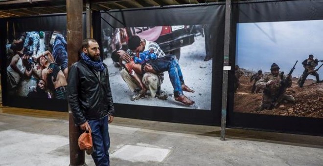 El fotoperiodista Manu Brabo posa ante varias de sus obras que forman parte de 'Un día cualquiera', una muestra que junto a National Geographic, ha inaugurado hoy en el centro cultural La Neomudéjar, en Madrid. EFE/Emilio Naranjo