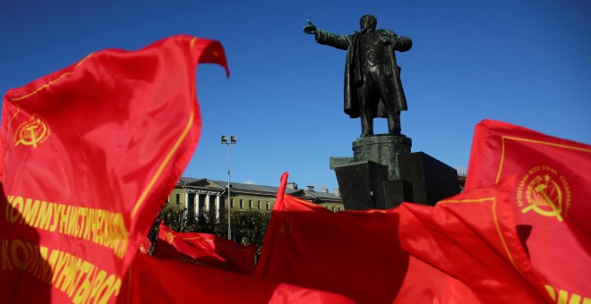 Banderas comunistas frente a la estatua de Vladimir Lenin en San Petesburgo. /REUTERS