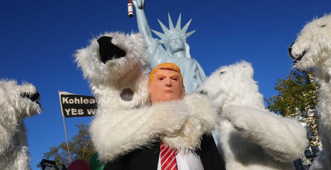 Un manifestante vestido con una máscara del presidente de EEUU Donald Trump junto a otros manifestantes disfrazados de osos polares, durante una manifestación de organizaciones ecologistas en Bonn, ante la cumbre del  clima COP23. REUTERS / Wolfgang Ratta