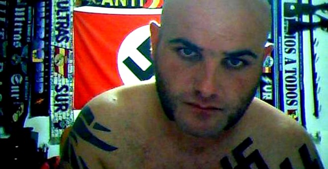 Antonio Reguera González, el 'Rambo del Bierzo', en su cuarto, rodeado de simbología nazi y armas y munición colgadas de las paredes. / LEONOTICIAS.COM