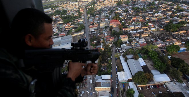 Un soldado hondureño con su fusil en un helicópero militar durante la operación denominada 'Paz y Democracia II', dentro de las medidas de seguridad en la campaña de las elecciones presidenciales. REUTERS/Jorge Cabrera