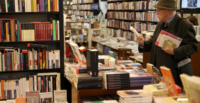 Una hombre hojea unos libros hoy en la librería la Central de Barcelona, en el Día de las Librerías.- EFE