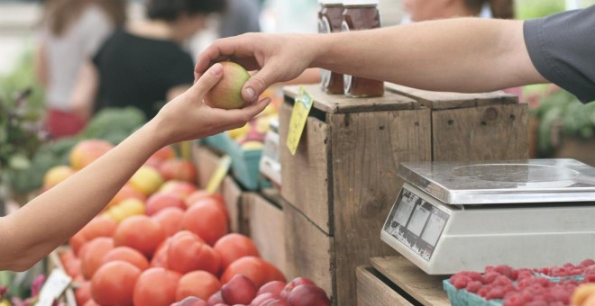 Una mujer compra en un puesto de frutas en un mercado. E.P.