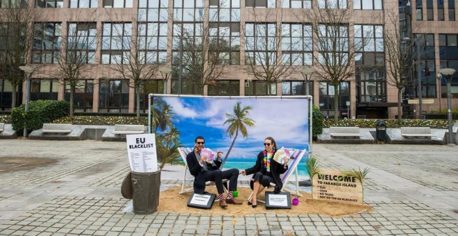 Dos actores 'toman el sol en un paraíso fiscal' durante una acción de protesta de Oxfam delante del Consejo Europeo, en Bruselas (Bélgica). EFE/ Stephanie Lecocq
