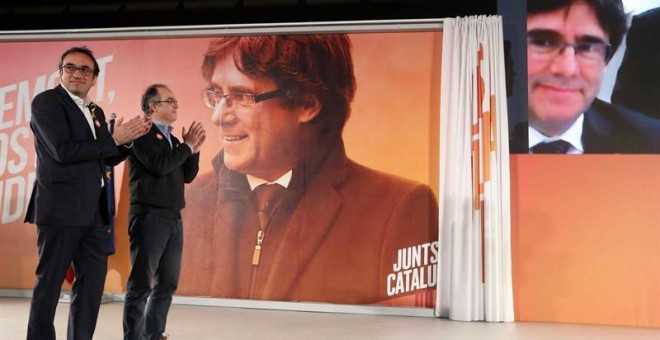 Los exconsellers y candidatos de JxSí Jordi Turull y Josep Rull (i) hablan por videoconferencia con el expresidente Puigdemont durante la rueda de prensa que han ofrecido después de salir de prisión. EFE/Toni Albir