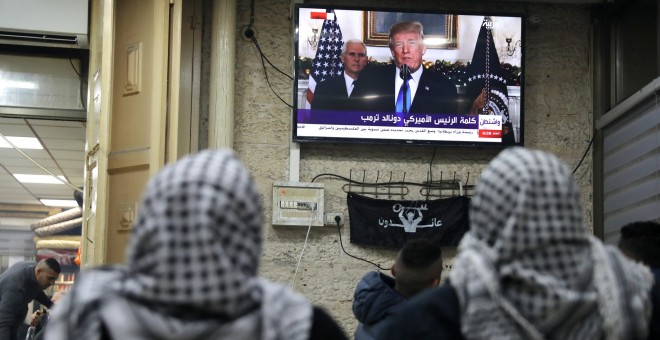 Palestinos escuchan el discurso de Trump en el que reconoce oficialmente a Jerusalén como capital de Israel. REUTERS/Ammar Awad