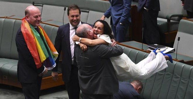 l diputado liberal Warren Entsch (c-i) coge en brazos a la diputada Linda Burney (c-d) mientras celebran la aprobación del matrimonio entre personas del mismo sexo en el Parlamento en Canberra (Australia) hoy, 7 de diciembre de 2017. El Parlamento austral