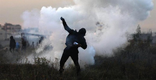 Un manifestante palestino devuelve una granada de gas israelí durante enfrentamientos cerca a la frontera con Israel. EFE/MOHAMMED SABER