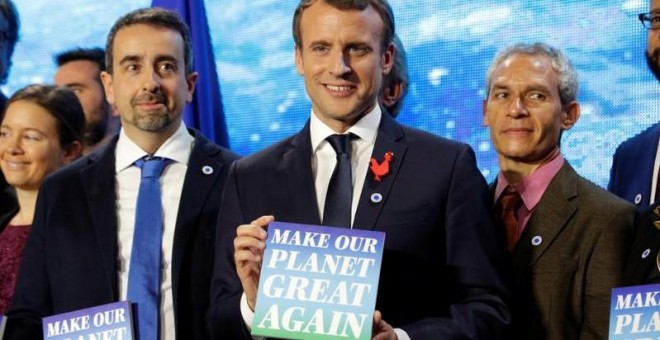 El presidente francés, Emmanuel Macron, en la cumbre One Planet Summit, con un cartel que dice 'Make our planet great again'.