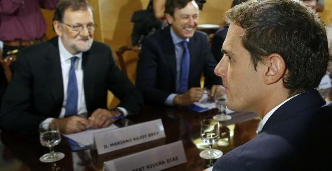 Mariano Rajoy y Albert Rivera, junto a otros miembros de sus partidos, durante la negociación del pacto de investidura. Archivo EFE / Sergio Barrenechea