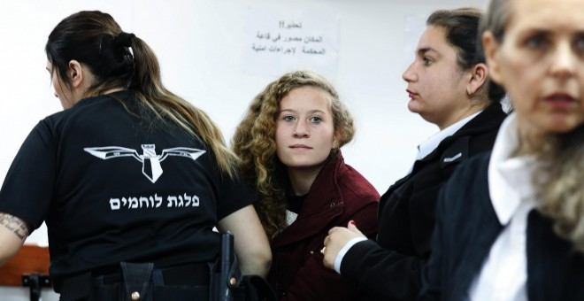 La adolescente palestina  Ahed Tamimi, es escoltada por agentes de la policía israelí hacia un juzgado en la localidad de Betunia (Palestina). EFE/ Abir Sultan