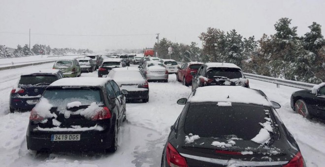 Fotografía facilitada por un conductor retenido en la A-6, a la altura del Km 75, en sentido Madrid. Familias atrapadas en sus coches por la nevada en la AP6 han pasado la noche en sus coches a la espera de que las máquinas quitanieve puedan desbloquear l