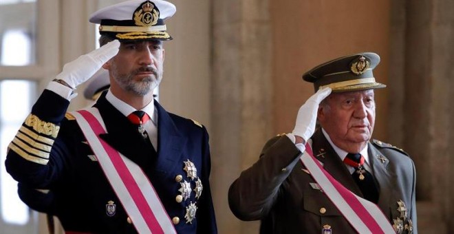 El Rey Felipe VI y el Rey emérito Juan Carlos, escuchan el himno nacional, a su llegada a la celebración hoy de la Pascua Militar en el Palacio Real. / EFE