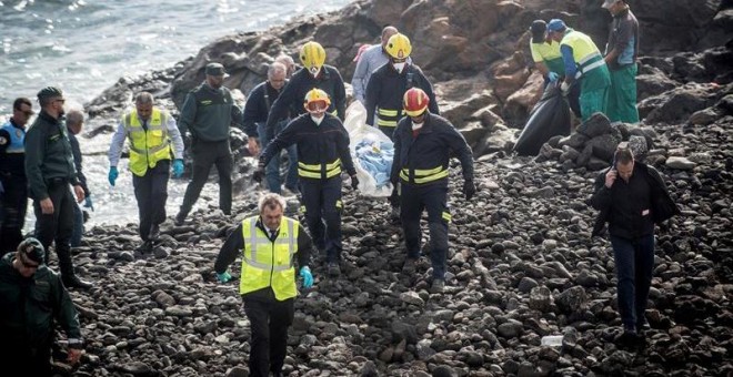 Efectivos de los servicios de Emergencias trasladan el cuerpo de uno de los fallecidos en la playa Bastián de Costa Teguise, donde seis inmigrantes magrebíes han perdido la vida y otros dos se encuentran en estado crítico tras encallar este mediodía una p