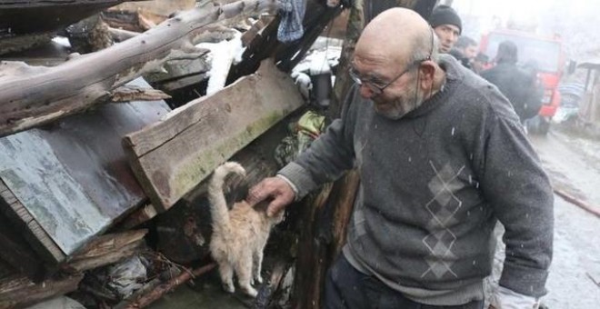 Anciano acariciando al único gato superviviente en el incendio de su casa. Facebook / NTV Radyo