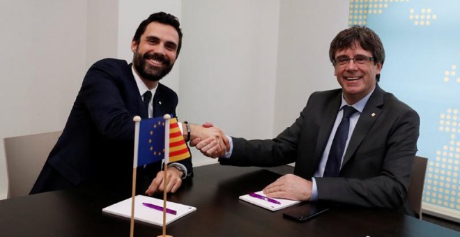 Roger Torrent y Carles Puigdemont se saludan al inicio de su reunión en Bruselas. | YVES HERMAN (REUTERS)