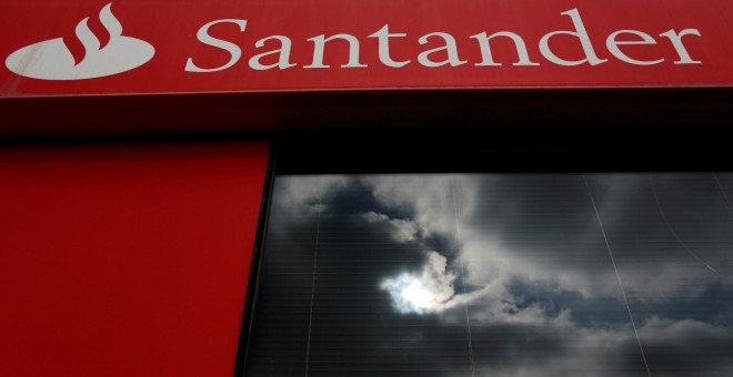 Las nubes se reflejan en la ventana de una sucursal del Banco Santander en Sevilla. REUTERS/Marcelo del Pozo