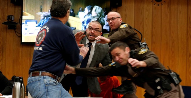 Momento en el que el padre de unas de las víctimas de Nassar intentar agredirlo durante el juicio.- REUTERS