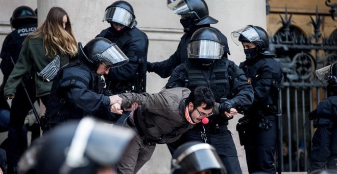 Agentes de los Mossos en el momento en el que desalojan a los manifestantes ante el TSJC. EFE/Quique García