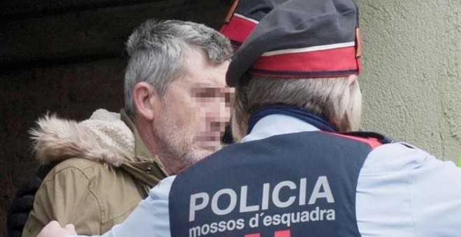 El presunto autor del doble homicidio de Susqueda, Jordi Magentí (i), acompañado de los mosos d'esquadra en el momento de acceder a una casa de Anglès. /EFE