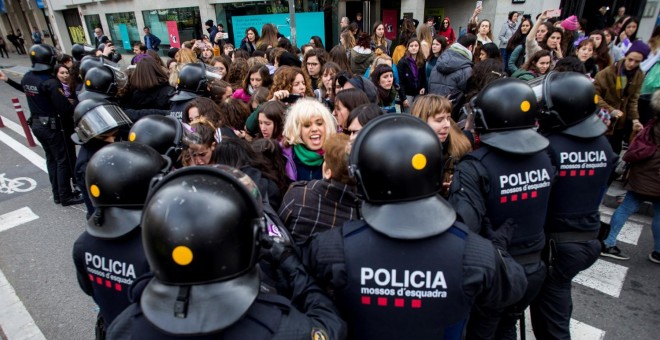 Efectivos de los Mossos d'Esquadra desalojan a un grupo de mujeres que cortaban la Gran Via de Barcelona.- EFE