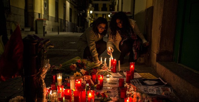 Dos jóvenes depositan velas en el lugar donde murió el mantero senegalés Mmame Mbage. JAIRO VARGAS